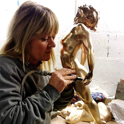 Photographie de l'artiste Bénédicte Dubart sculptant un bronze