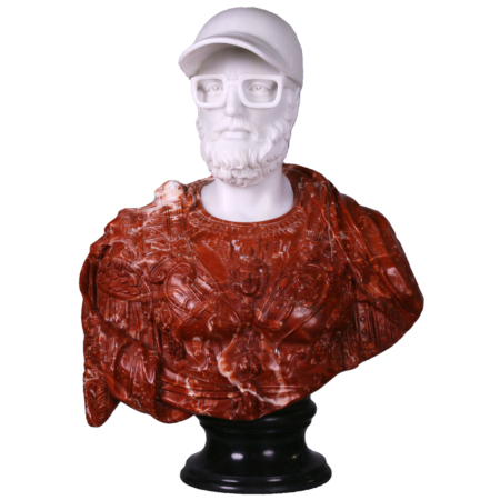Cette image est une sculpture de l'artiste Léo Caillard, intitulée "Red Lucius ". Cette pièce unique de 75 cm, réalisée en marbre rouge et en marbre blanc représente un buste d'un empereur romain, avec des attributs contemporains : une casquette et des grosses lunettes. Vous pouvez retrouver cette pièce à la Galerie Montmartre à Paris, France.