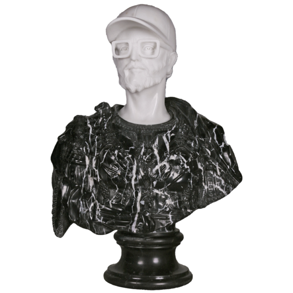 Cette image est une sculpture de l'artiste Léo Caillard, intitulée "Black Lucius". Cette pièce unique de 75 cm, réalisée en marbre blanc et en marbre noir représente un buste de l'Empereur romain Lucius Verus, avec des attributs contemporains : une casquette et des grosses lunettes. Vous pouvez retrouver cette pièce à la Galerie Montmartre à Paris, France.