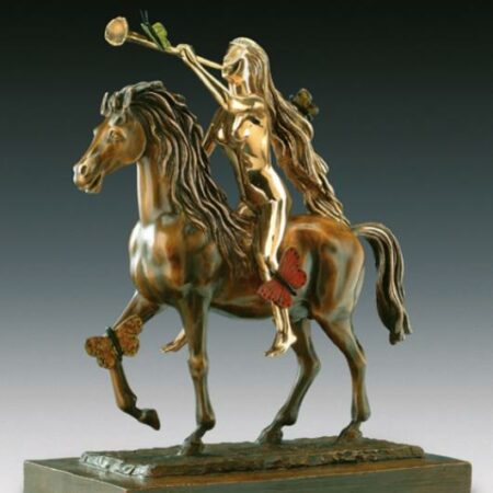 Cette image représente une sculpture de l'artiste Salvador Dalí. Elle est réalisée en bronze à la cire perdue. Elle représente Lady Godiva sur un cheval avec une trompette à la bouche et à la main. Elle mesure 63,5 cm et est exposée à la Galerie Montmartre à Paris, France.